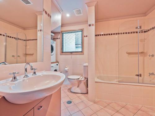 een badkamer met een wastafel, een douche en een toilet bij Lhotsky 2 Bedroom with fireplace and sweeping mountain view in Thredbo