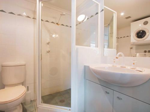 a white bathroom with a sink and a shower at Lhotsky 1 Bedroom apartment with tranquil outlook and onsite parking in Thredbo