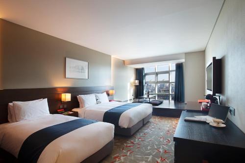 a hotel room with two beds and a television at ASTI Hotel Busan Station in Busan