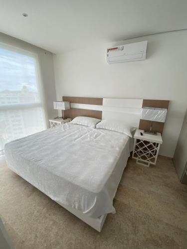 Un dormitorio con una gran cama blanca y una ventana en Apartamento Le Club Acapulco, en Acapulco