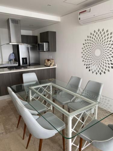 a dining room with a glass table and chairs at Apartamento Le Club Acapulco in Acapulco