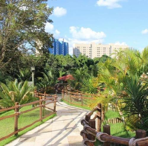 een loopbrug in een park met palmbomen en gebouwen bij Thermas do Bosque - Apt 311 in Caldas Novas