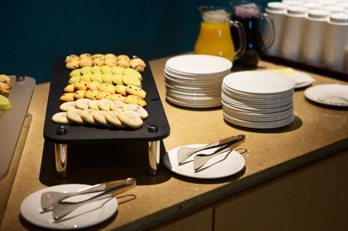 a table with plates and a tray of food at ASTI Hotel Busan Station in Busan