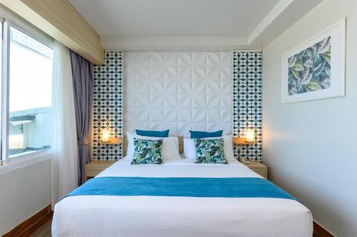 a bedroom with a large bed and a window at Maldives Beach Resort in Chao Lao Beach