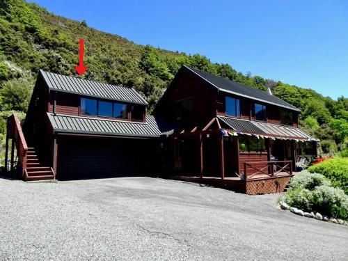 a large house with a garage next to a mountain at The Loft at Bealey in Arthur's Pass
