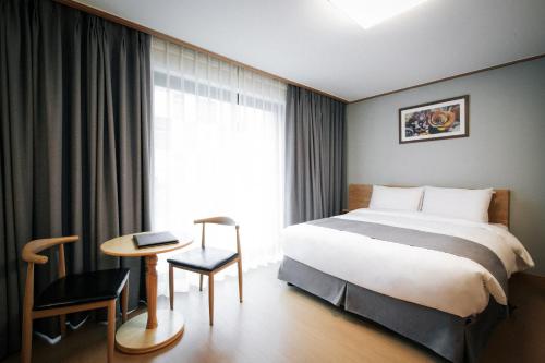 a hotel room with a bed and a table and a window at The N Resort Hotel&Spa YangYang in Yangyang