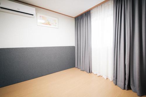 a room with a large window with curtains at The N Resort Hotel&Spa YangYang in Yangyang