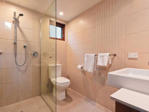 een badkamer met een douche, een toilet en een wastafel bij Snow Stream 3 Bedroom and loft with gas fire garage parking and balcony in Thredbo