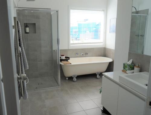 uma casa de banho com uma banheira, um chuveiro e um lavatório. em Retreat em Albany