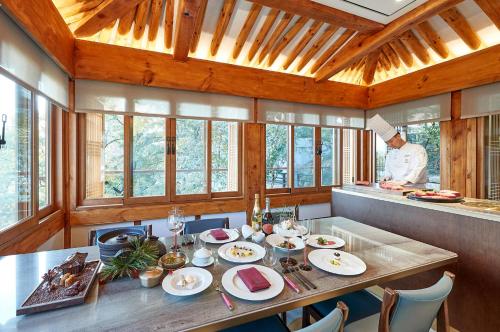 a dining room with a table and a chef in the kitchen at Vista Walkerhill Seoul - formerly W Seoul in Seoul