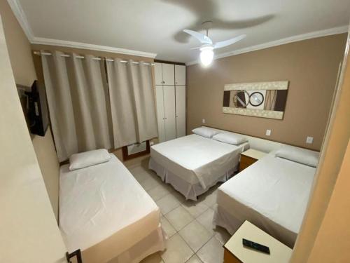 een hotelkamer met twee bedden en een tv bij Flat Riviera de São Lourenço in Riviera de São Lourenço