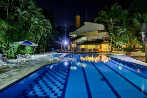 een zwembad in een resort 's nachts bij Flat Riviera de São Lourenço in Riviera de São Lourenço