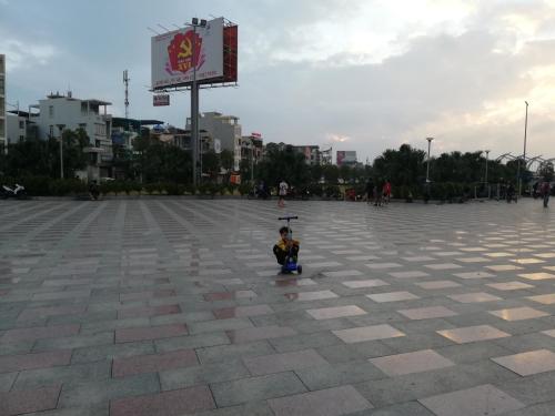 a small child sitting on the ground in a plaza at BA CON ECH Home and Stay- No 28 lane 259 Nguyen Duc Canh in Hai Phong