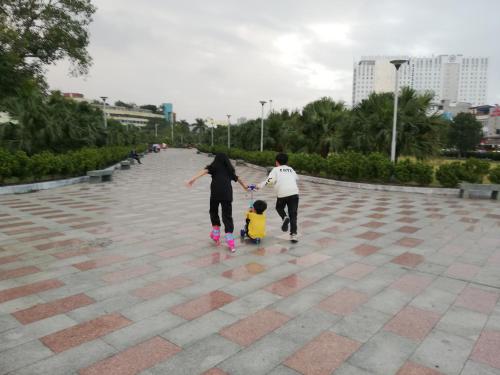 two adults and a child walking down a sidewalk at BA CON ECH Home and Stay- No 28 lane 259 Nguyen Duc Canh in Hai Phong