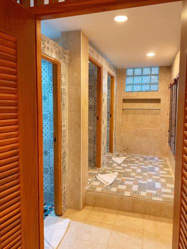 a bathroom with a shower with a tiled floor at Sasidara Resort Nan in Nan