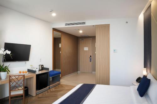 a hotel room with a bed and a tv at Aston Kemayoran City Hotel in Jakarta