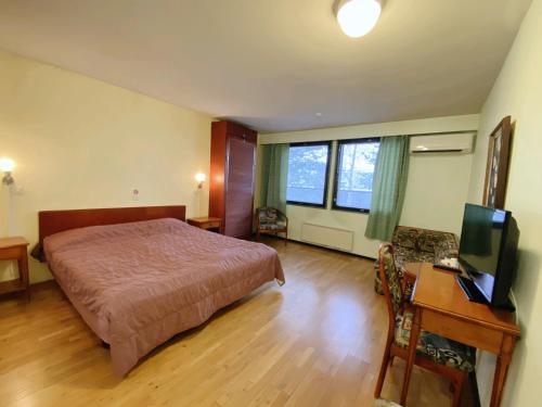 Dormitorio con cama, escritorio y TV en Kitusen Kievari, en Virrat