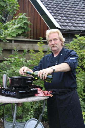 a man is preparing a pan on a grill at B&B Harskamp in Harskamp