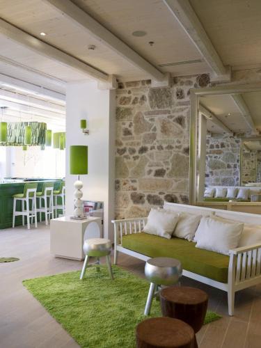 a living room with a couch and a stone wall at Salvator Villas & Spa Hotel in Parga