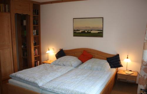 una camera con un letto con due cuscini e due lampade di Ferienhaus am Chiemsee a Breitbrunn am Chiemsee