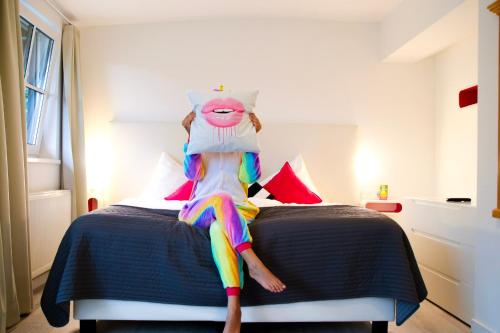 a person is sitting on a bed with a costume at Hotel Saalbacher Hof in Saalbach Hinterglemm