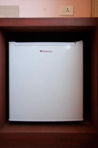 a white refrigerator sitting in a wooden shelf at Hotel Krishna Kathmandu in Kathmandu