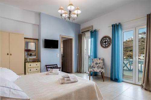 a bedroom with a bed and a chair and a clock at Niriides Luxury Studios in Astypalaia