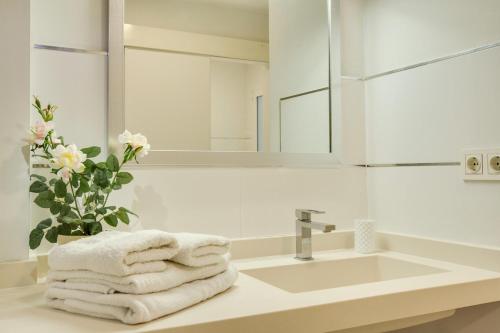 a bathroom with a sink and a mirror and towels at Fantástico Apartamento cerca Playa in Las Palmas de Gran Canaria