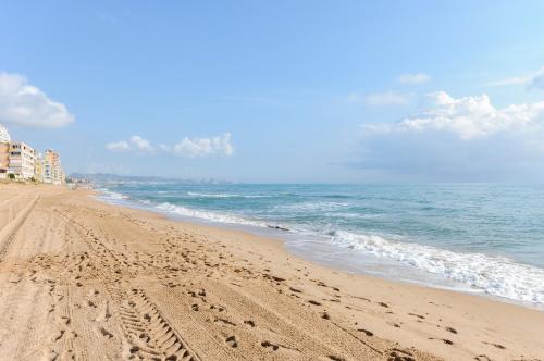 a beach with footprints in the sand and the ocean at Turia in Tavernes de Valldigna