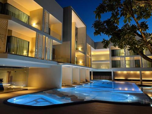 an external view of a building with a swimming pool at The Signature Hotel Airport in Hat Yai