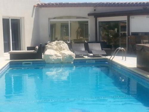 una gran piscina con sillas y una piscina en La Pinède D'Estarac, en Bages
