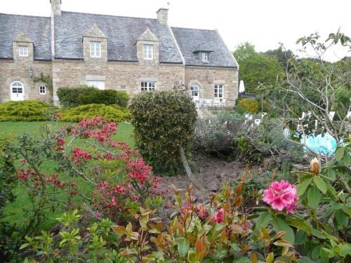 una gran casa de ladrillo con flores delante en Chambres d'hotes "Manoir Des Quatre Saisons", en La Turballe