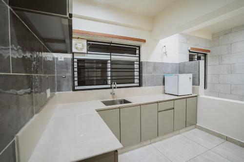 a white kitchen with a sink and a window at Fortune Avenue in Mattanūr