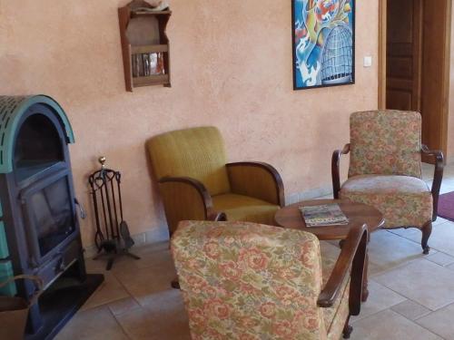 ein Wohnzimmer mit Stühlen, einem Tisch und einem TV in der Unterkunft Le Jardin de Norah in Brulange