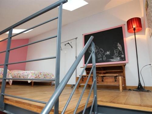 ein Wohnzimmer mit einer Treppe und einem großen TV in der Unterkunft Le Jardin de Norah in Brulange