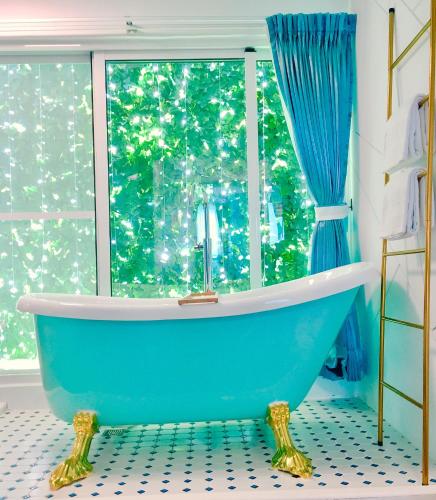a blue tub in a bathroom with a window at 海角42號一館Villa包棟民宿 in Hengchun South Gate