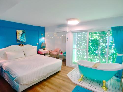 a blue bedroom with a bed and a bath tub at 海角42號一館Villa包棟民宿 in Hengchun South Gate