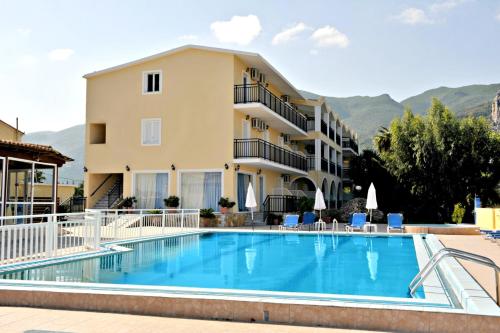 a hotel with a swimming pool in front of a building at Pothos Hotel Alykes in Alykes