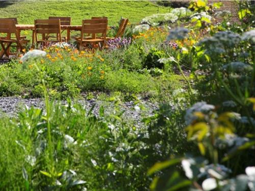 - un jardin avec des chaises, une table et des fleurs dans l'établissement Chambres d'hôtes-Les Chambres de Mado, à Margencel