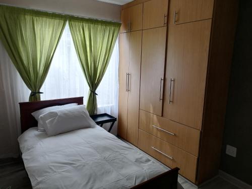 a bedroom with a bed and a dresser and a window at BLS (Baie Lekker Slaap) in Bloemfontein