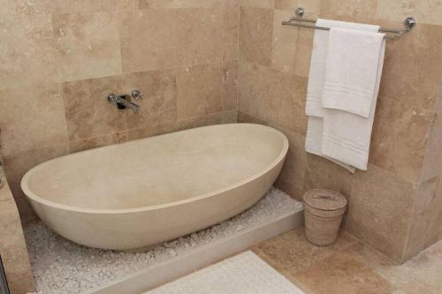 a bathroom with a large tub and a towel at 4 Bedroom Luxury Home with View of the Ocean and Table Mountain in Cape Town