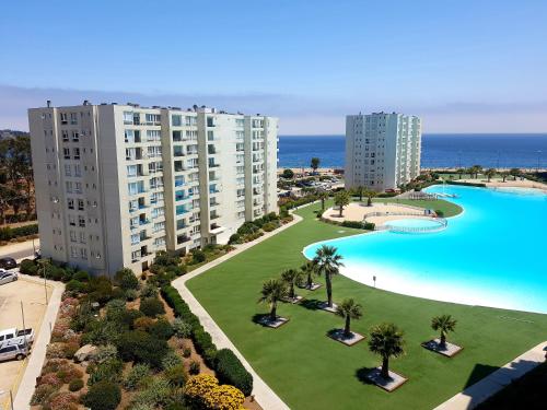 una vista aérea de una gran piscina con palmeras y edificios en Departamento Lago & Mar en Papudo