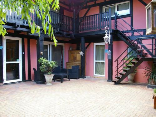 a pink building with a staircase and a patio at Chambres d'Hôtes Le Domaine des Remparts in Sélestat