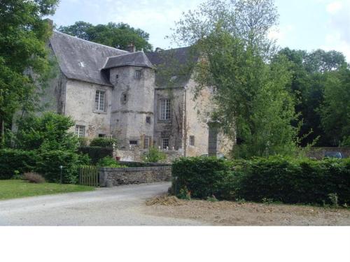 an old stone building with a roof on a street at Manoir de Rouessé in Laval