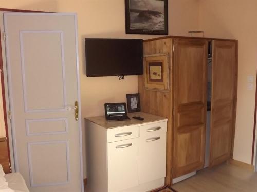 a bedroom with a tv and a cabinet and a door at Manoir de Rouessé in Laval