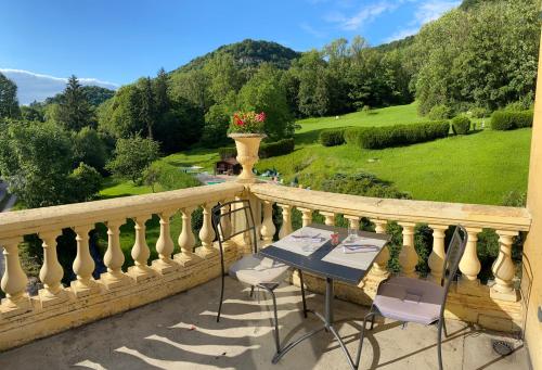 a table and chairs on a balcony with a view at Domaine Du Moulin Vallée Heureuse in Poligny