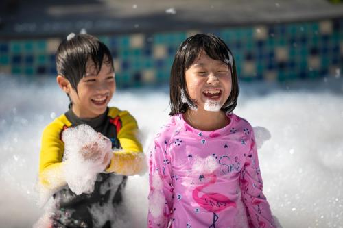 two young children playing in the snow at Grande Centre Point Pattaya in Pattaya Central