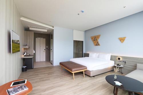 a hotel room with a bed and a table at The Signature Hotel Airport in Hat Yai