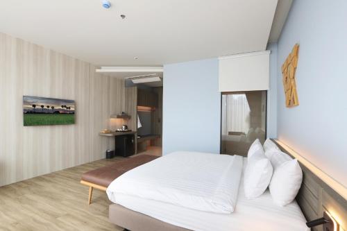 a bedroom with a large white bed with white pillows at The Signature Hotel Airport in Hat Yai