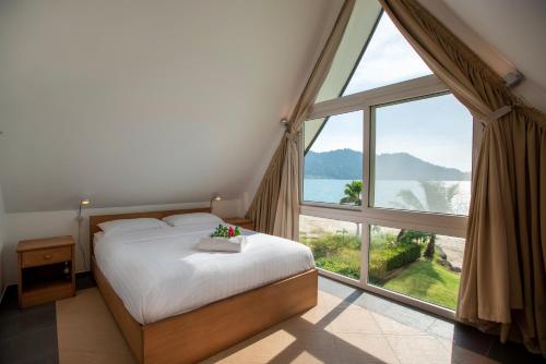 a bedroom with a bed and a large window at Utalay Koh Chang Villas in Ko Chang